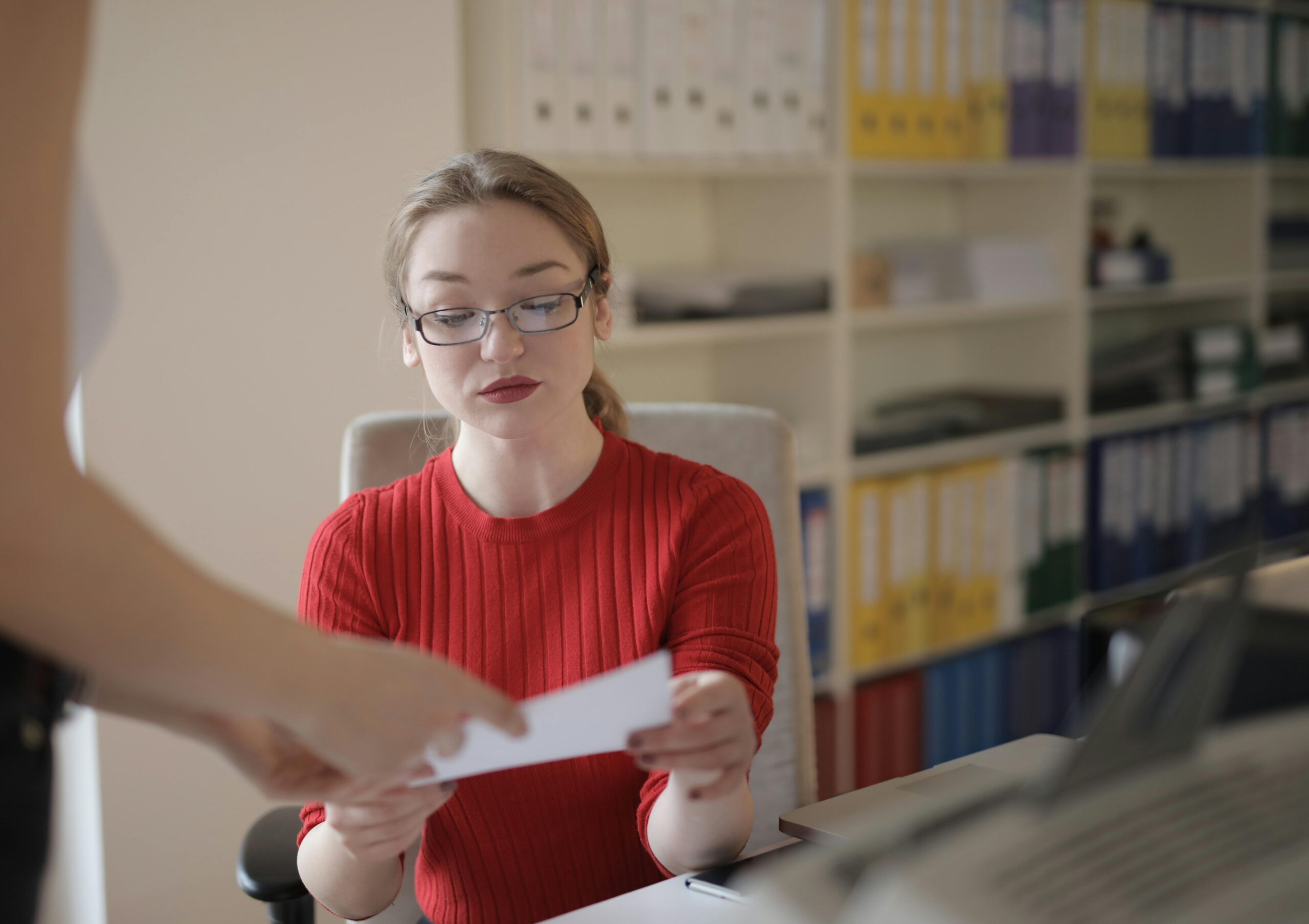 Young woman examining document in office